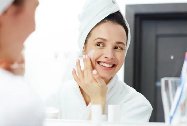 Woman applying moisturizing face cream